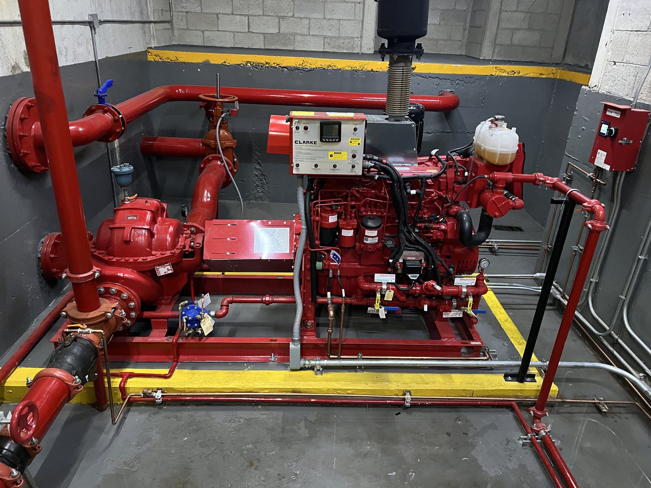 Fire pump coupled to a Clarke diesel engine, with its control panel and the suction and discharge piping.