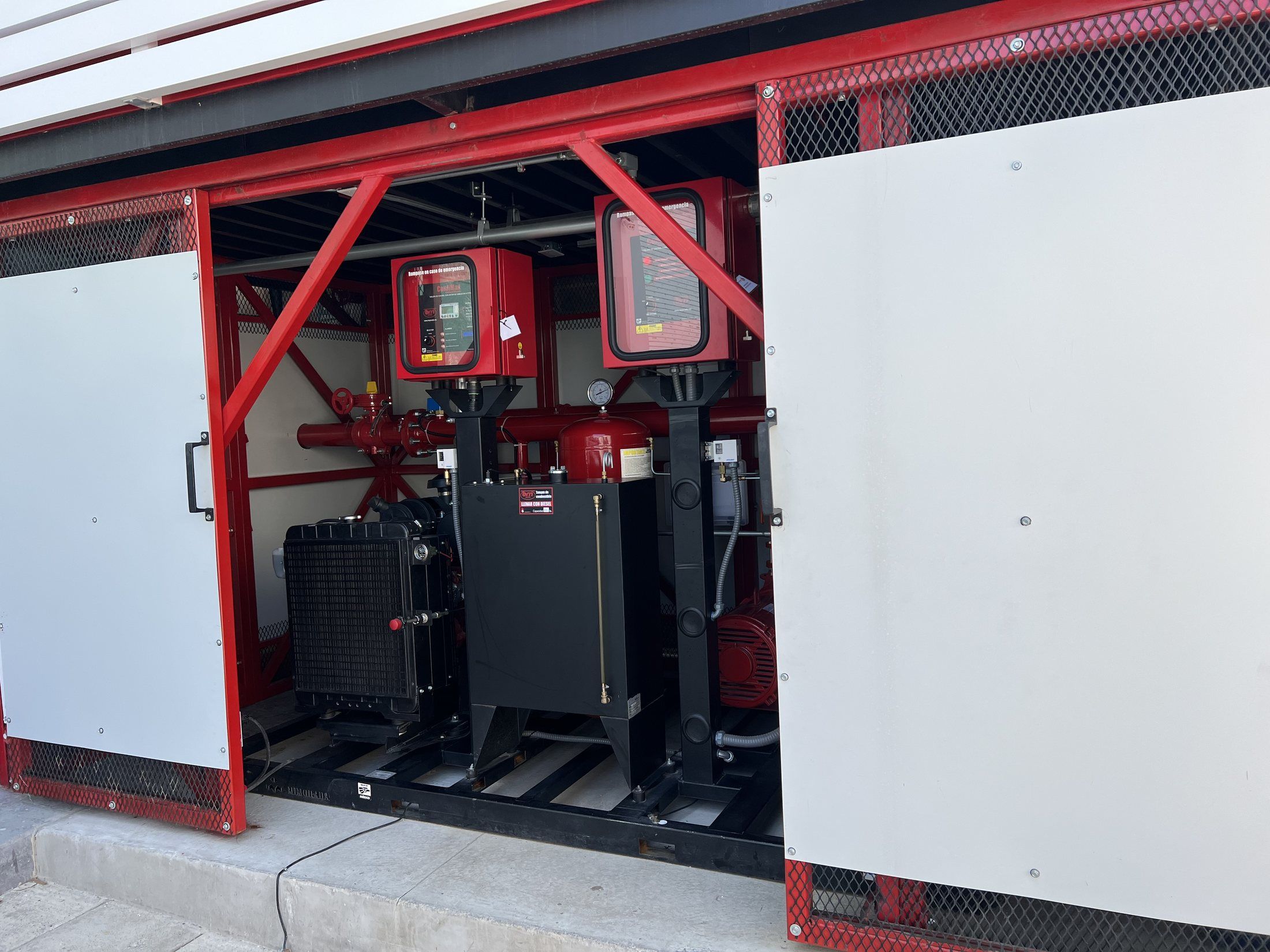 Fire pump equipment in an outdoor pump house, with controllers and a diesel engine.