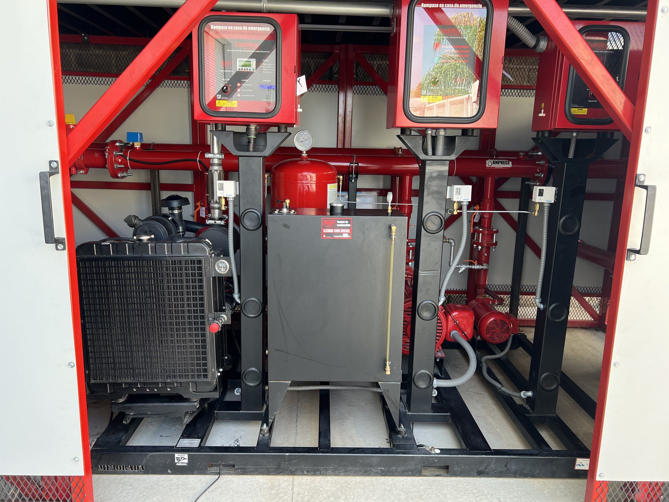 Inside the pump house: three pump controllers, the diesel engine with its radiator, and the fuel tank.