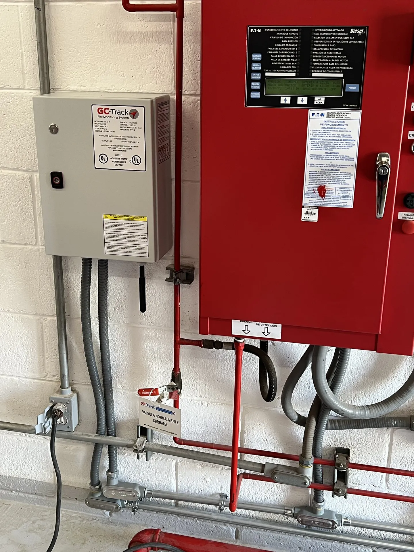 Fire pump controller and monitoring unit mounted on a wall, with their conduit.