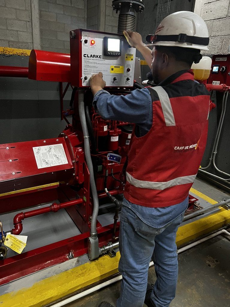 A CAAF de México technician operates the Clarke control panel of a diesel fire pump engine.