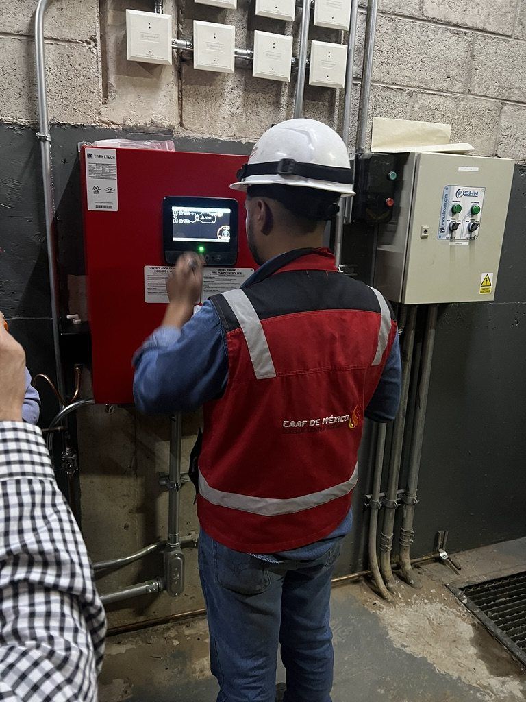 A CAAF de México technician checks the display of a fire pump controller.